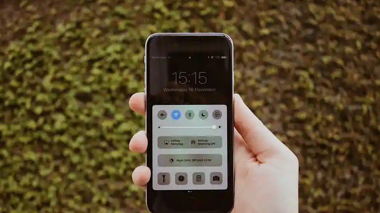 A hand holding a smartphone with its notifications showing