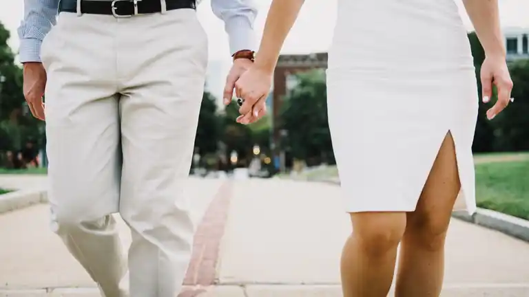Two people walking side by side, holding hands